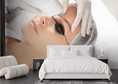 Young woman undergoing laser removal of permanent makeup in salon. Eyebrow correction Wall mural