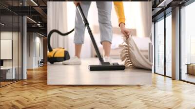 Young woman using vacuum cleaner at home, closeup Wall mural