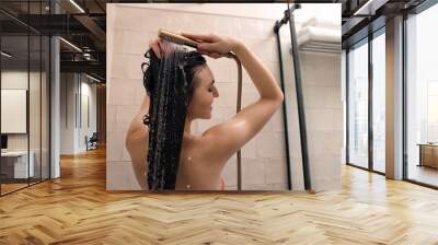 Young woman washing hair while taking shower at home Wall mural