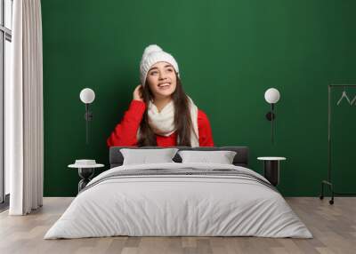 Young woman wearing warm clothes on color background, space for text. Winter season Wall mural