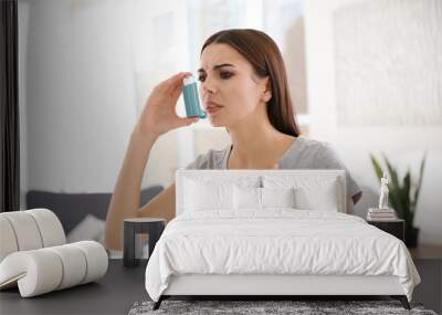 Young woman with asthma inhaler in light room Wall mural