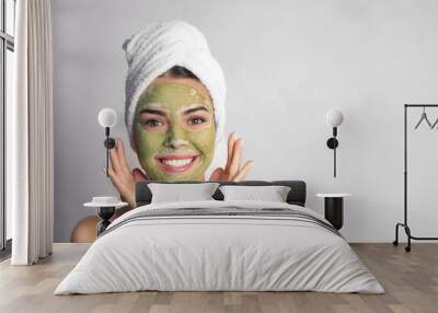 Young woman with clay mask on her face against light background, space for text. Skin care Wall mural