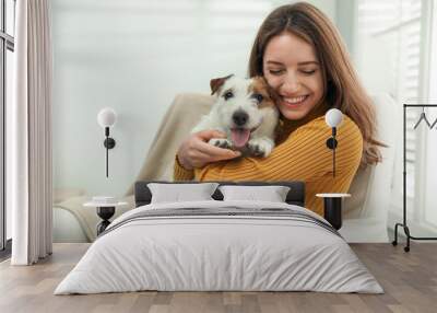 Young woman with her cute Jack Russell Terrier at home. Lovely pet Wall mural