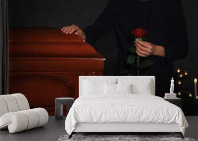 Young woman with red rose near casket in funeral home, closeup Wall mural