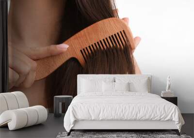 Young woman with wooden hair comb on white background, closeup Wall mural