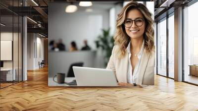 Beautiful business woman in a glasses with smile and a laptop in her hands in the office near a white wall with blank space Wall mural