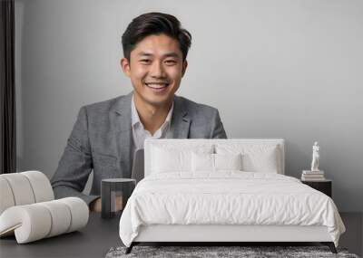 Young Asian business man using laptop computer and smiling looking at camera isolated on white background Wall mural