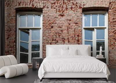 Two vintage windows on brick wall  in  urban setting  Wall mural