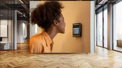 A face scanner being used by a woman to open a door at an office building. Control device for Security system. Device to control a security system. Wall mural