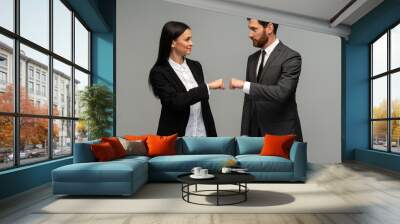 Caucasian businessman and woman working together, bumping fists with each other. Cooperative and teamwork concept Wall mural