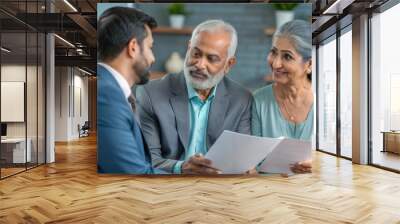 Indian financial advisor explaining retirement paperwork to a couple in their living room.
 Wall mural