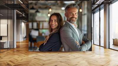 Successful happy businessman and businesswoman standing back to back with arms crossed and smiling at camera, office interior. Partnership concept - generative ai Wall mural