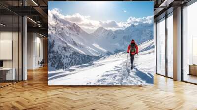 Hiker trekking through snowy mountains with a clear blue sky, showcasing the adventure and serenity of winter mountaineering in pristine alpine landscapes. Wall mural