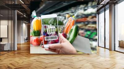 Online order grocery shopping on touch screen concept. Woman hand holding smart phone with checks the bar code or e-wallet on label for ingredient and payment. Business and technology for lifestyle. Wall mural