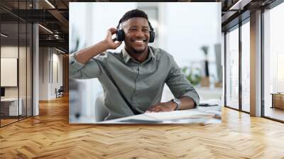 Black man, headphones and listening to music in office with smile for sound track or podcast. Happy African male person or professional designer smiling with headset enjoying audio at the workplace Wall mural