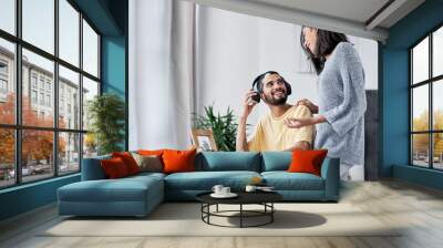 Blending home life with business life. Shot of a happy young couple working from home. Wall mural