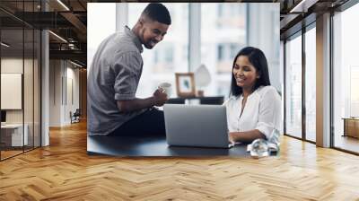 Coming together to source the solutions they need. Shot of two businesspeople working together on a laptop in an office. Wall mural