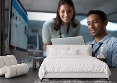 Growth comes from the kind of work you give. Shot of a young businessman and businesswoman using a digital tablet in a modern office. Wall mural