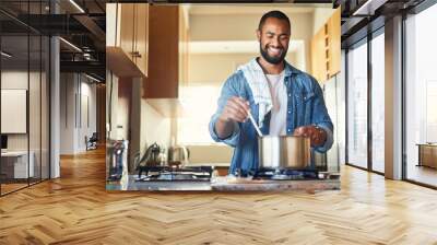 I cant wait until its done. Shot of a young man cooking at home. Wall mural