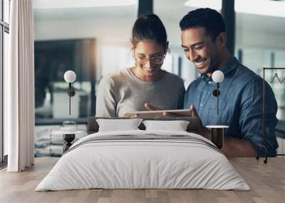 its easy to talk big. Shot of two young workers using a digital tablet in a modern office. Wall mural