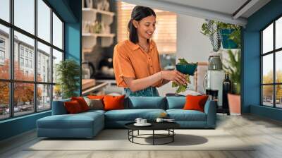 Leafy greens add goodness to any meal. Shot of a happy young woman preparing a healthy meal at home. Wall mural