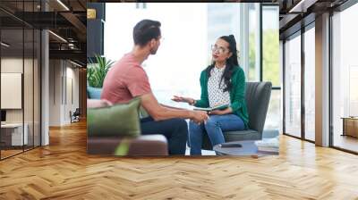 Mental health, therapy or counseling with a woman psychologist and male patient talking in her office. Psychology, wellness and trust with a female doctor or shrink consulting a man for healing Wall mural