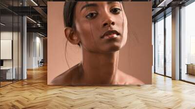 My lungs were riddled with our fears. Portrait of a beautiful young woman posing against a brown background. Wall mural