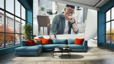 Never be afraid to succeed. Shot of a young business man working in a modern office. Wall mural