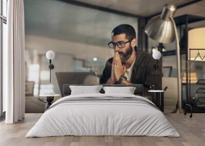 Please work, please work. a young businessman looking anxious while using a laptop during a late night at work. Wall mural