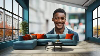 Success happens the moment you believe it will. Portrait of a confident young businessman standing against an urban background. Wall mural