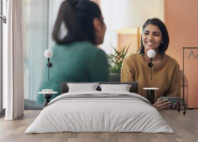 Talking to my sister is all the therapy I need. Shot of two young women drinking coffee while sitting together at home. Wall mural