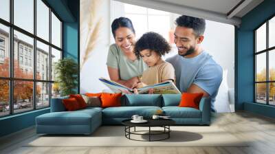 Teaching her some new things. Shot of a young family reading a book together at home. Wall mural