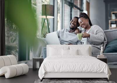 Who knew staying home could be the best cinematic experience. a young couple using a laptop together on the sofa at home. Wall mural