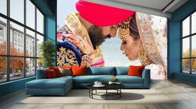 Sikh bride and groom posing on a tropical beach beneath bright blue skies Wall mural