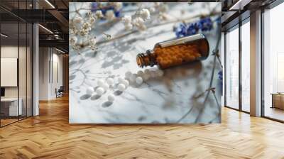 Homeopathic Medicine Bottle with White Pellets and Dried Flowers on Marble Surface Wall mural