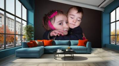 Boy and girl hugs together and smile. Brother and sister in studio Wall mural