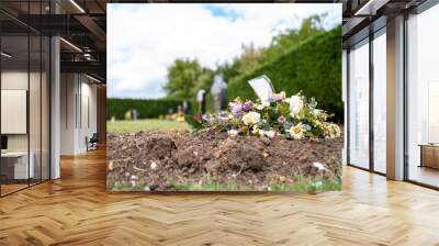 Shallow focus of wilted flowers seen on a fresh grave in a cemetery. The cemetery is in a rural English village. Wall mural