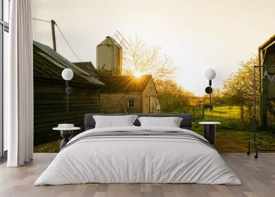 Sunset over a rural dairy farm in England. A paddock with horses can be seen and an old metal grain silo to once feed dairy cows can be seen near the abandoned milking parlour. Wall mural