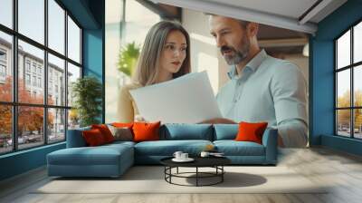 Businesswoman discuss business with businessman Caucasian male and female colleague at computer in office Wall mural