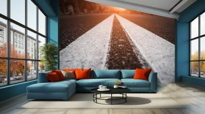 Asphalt city road with white lines ahead and the sunset Wall mural