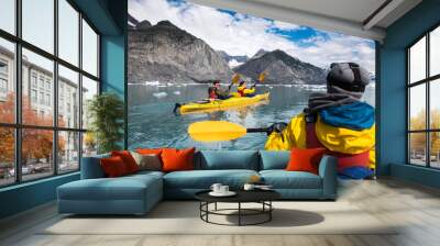 Group of friends enjoy ocean kayaking bear glacier during their vacation trip to in Alaska, USA Wall mural