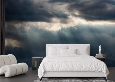 Dramatic dark and light cloudy sky with rays of sunlight Wall mural