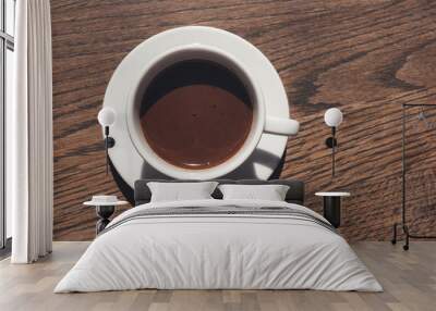 Cup of coffee on wooden table, top view Wall mural