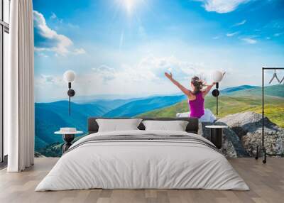 Young woman on the top of mountain Wall mural