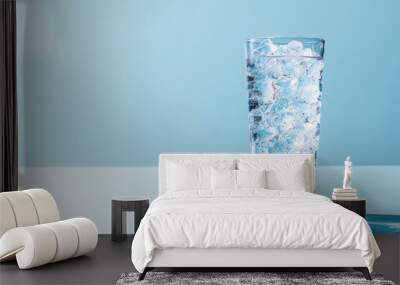 A glass of water with ice cubes in it with copy space Wall mural