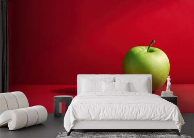 A green apple sits on a red background with copy space Wall mural