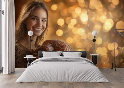 Smiling Woman Holding a Roasted Turkey with Golden Bokeh Background Wall mural