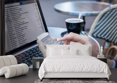 business person reading emails on smartphone and laptop computer screen Wall mural