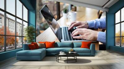 Hands typing on laptop computer keyboard, person writing email or report document in cafe with coffee and wifi internet, casual style, copy-space Wall mural