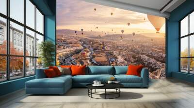 Hot air balloons flying above Göreme, Cappadocia (Kapadokya) Anatolia, Turkey at sunrise. Panoramic view of villages and fairy chimneys. Popular touristic destination for summer vacation holidays Wall mural